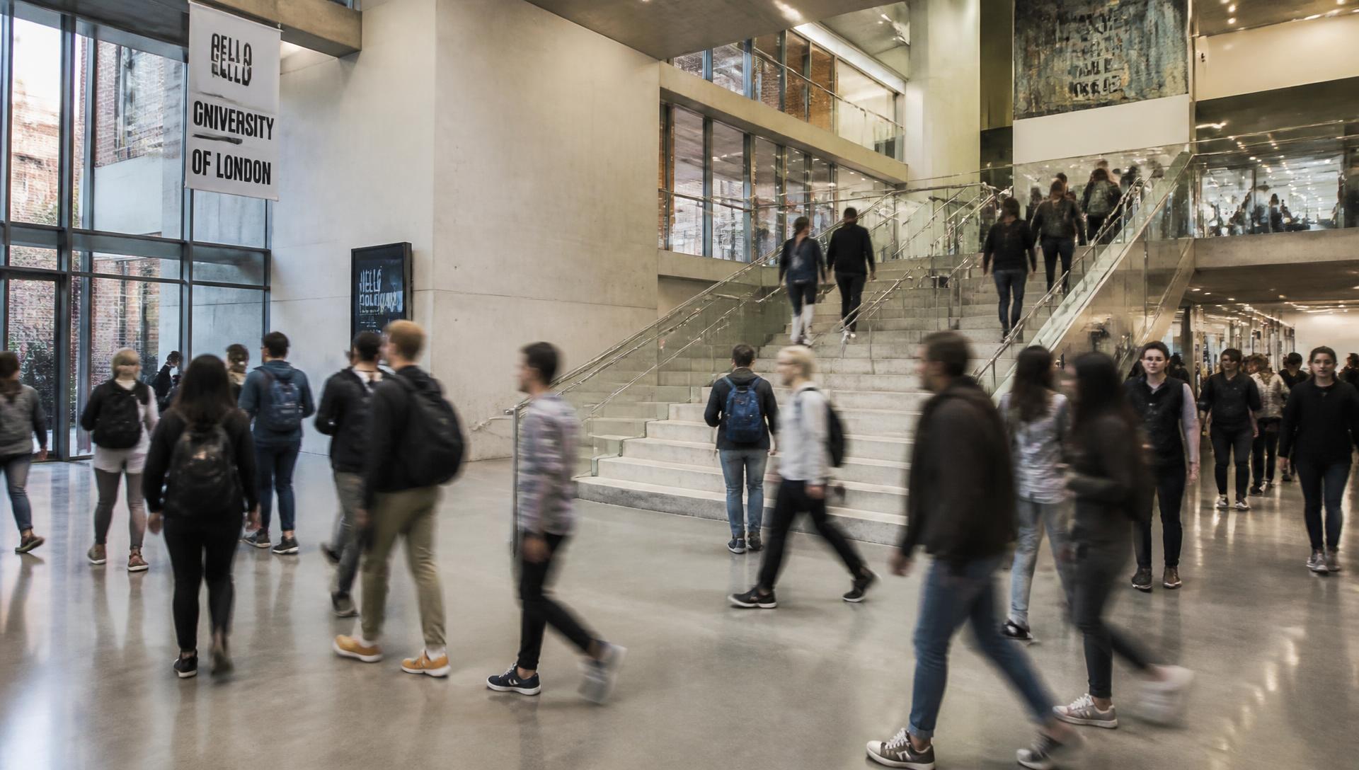 Students moving through a university atrium between sessions