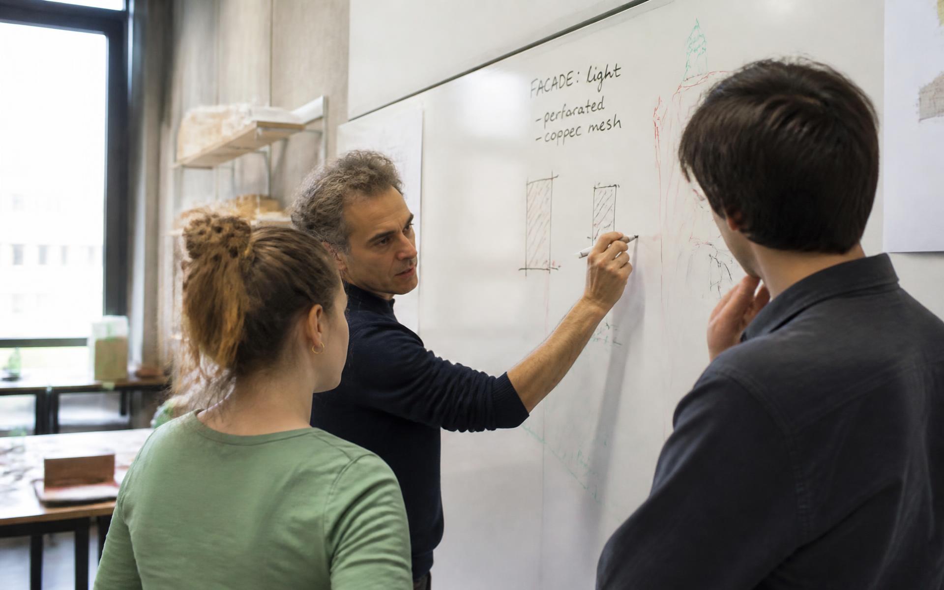 A teacher working alongside students in a classroom setting
